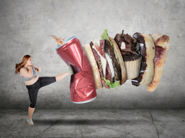 Übergewichtige Frau tritt gegen ungesundes Essen