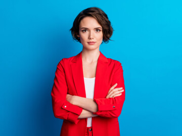 junge Frau mit verschränkten Armen, rotes Jacket