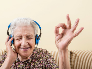 Ältere Frau hört Podcast