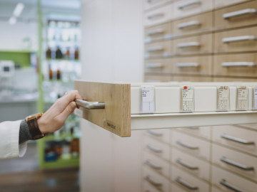 Hand zieht Apothekerschrank auf