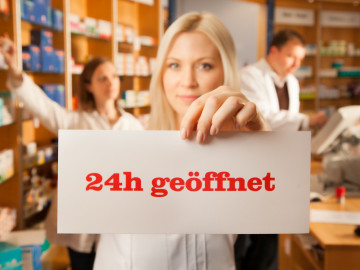 PTA hält Schild mit „24 h geöffnet“ in die Kamera