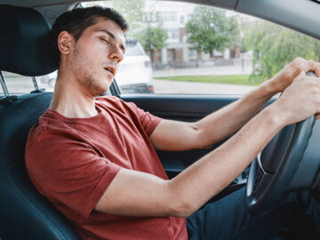 Mann schläft am Steuer von Auto