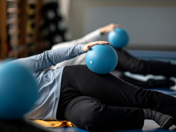 Frauen trainieren mit einem blauen Gynastikball