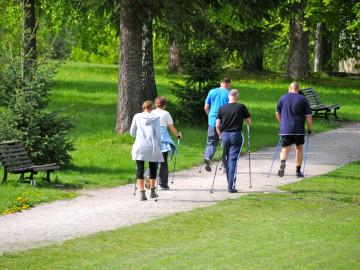 Eine Gruppe älterer Menschen, die durch einen Park walkt.