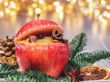 Bratapfel gefüllt mit Zimt, Nüssen und Rosinen, arrangiert im weihnachtlichen Ambiente