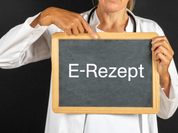 Ärztin zeigt auf Tafel mit dem Begriff E-Rezept