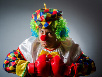 Clown mit roten Boxhandschuhen mach grimmiges Gesicht