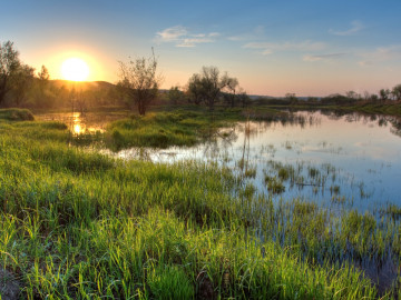 Landschaftsbild mit Gewässer und Sonnenuntergang