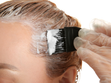 Junge Frau färbt sich die Haare selbst