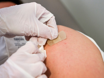 Pflaster wird auf Impfeinstichstelle geklebt