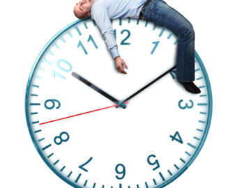 Uhr steht auf 10:10, obenauf schläft ein Mann