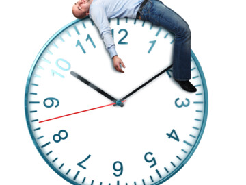 Uhr steht auf 10:10, obenauf schläft ein Mann