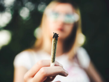 Frau hält einen Joint