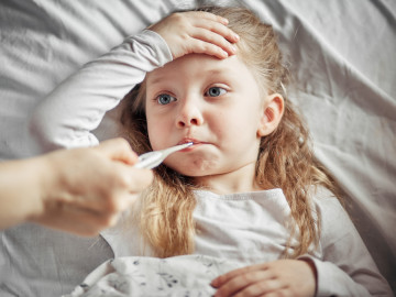 Mädchen mit Fieberthermometer im Mund