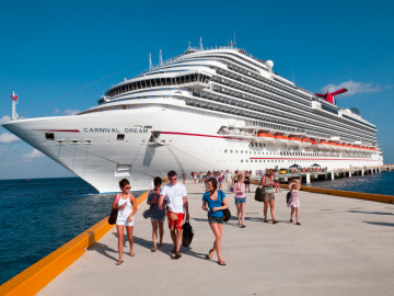 Passagiere auf Landgang vor einem großen Kreuzfahrtschiff