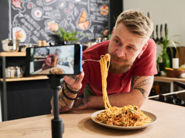 Mann isst vor laufender Handykamera Spaghetti