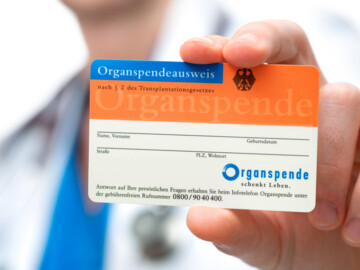 Arzt hält einen Organspendeausweis in die Kamera#