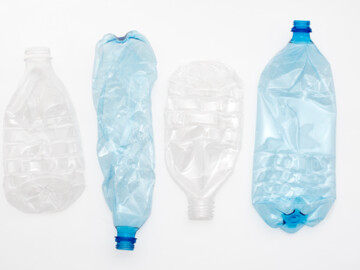 Leere weiße und blaue Plastikflaschen, zerdrückt und abwechselnd angeordnet