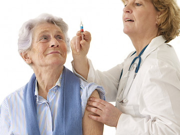 Ärztin zieht Spritze auf, um Seniorin zu impfen