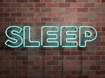 Leuchtendes Wort „Sleep“ auf Backsteinmauer