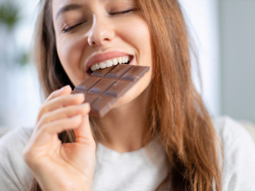 Frau beißt in Schokoladentafel
