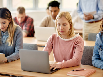 Schülerinnen und Schüler mit Laptop im Klassenzimmer