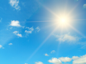 Sonne scheint am blauen Himmel, ein paar Wolken sind zu sehen.