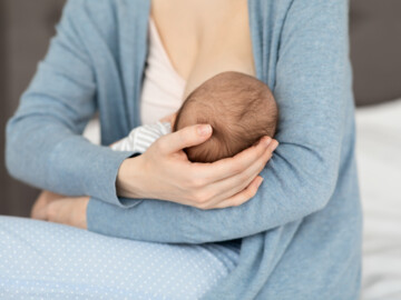 Baby beim Stillen an der Brust der Mutter