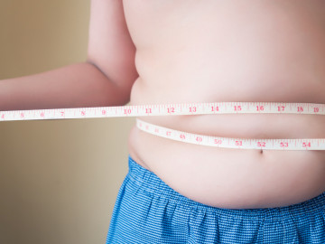 Übergewichtiger Mann misst Bauchumfang