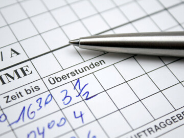 Zettel und Kugelschreiber: Eintrag von Überstunden