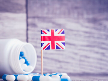 Blau-weiße Kapseln und eine Landesflagge von Groß-Britannien