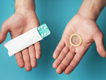 Kondom und Blisterpackung mit der “Pille” werden in die Kamera gehalten