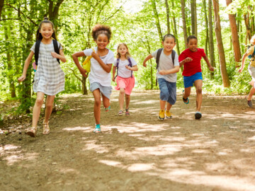 Gruppe Kinder beim Rennen in der Natur im Sommer