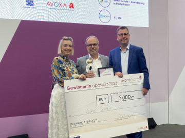 Übergaben den Preis auf der Expopharm in Düsseldorf an Schulleiter Burkhard Pölzing (Mitte): Moderatorin Inga Bergen (l.) und Jan Wagner (r.) vom Wort und Bild Verlag.