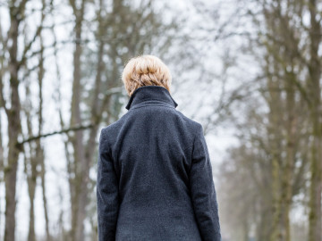 Frau von hinten gezeigt geht durch Winterwald