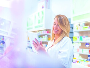 PTA mit Tablet in der Apotheke