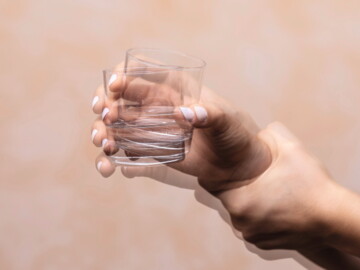 Hand mit Wasserglas in Bewegung