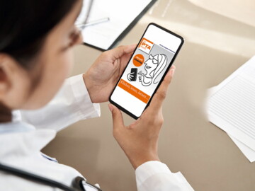 Frau blickt auf Smartphone mit eTraining Anzeige auf dem Bildschirm.