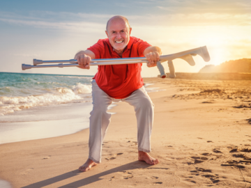 Mann mit Gehilfe am Strand