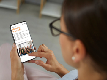 Frau mit Handy und eTraining Impfstoffe auf dem Display