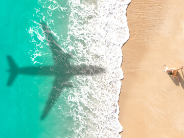 Schatten eines Flugzeugs über dem Strand 