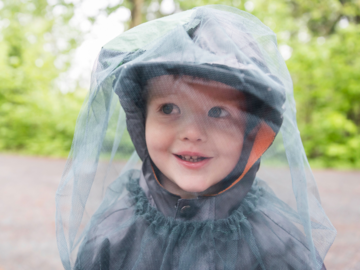 Kind mit Insektenschutznetz auf dem Kopf